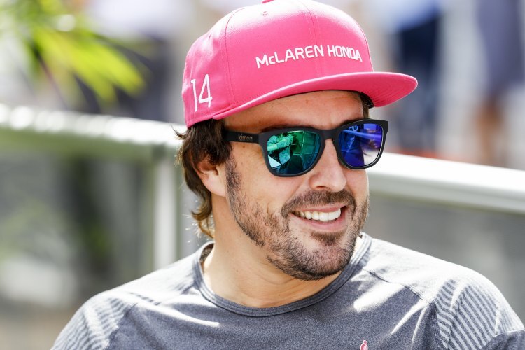 Im Formel-1-Paddock ist Fernando Alonso mit einer farbintensiven Mütze unterwegs