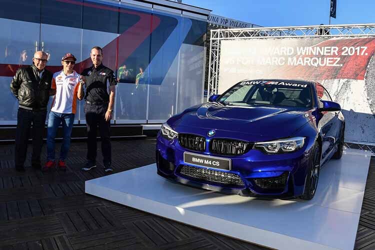 Marc Márquez mit dem BMW M4 CS sowie Carmelo Ezpeleta (Dorna) und Frank van Meel (BMW M)