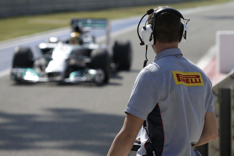 Ein Pirelli-Techniker beobachtet, wie Lewis Hamilton in Mercedes an die Box zurückkommt