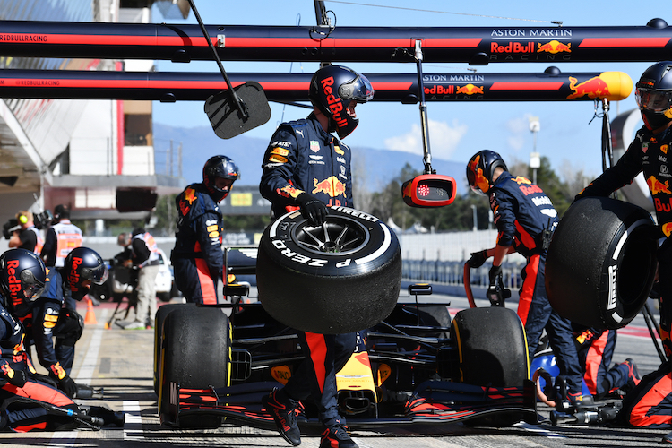 Ein Mechaniker mit einem C2-Reifen (weiss markiert), am Wagen steckt die C3-Mischung von Pirelli