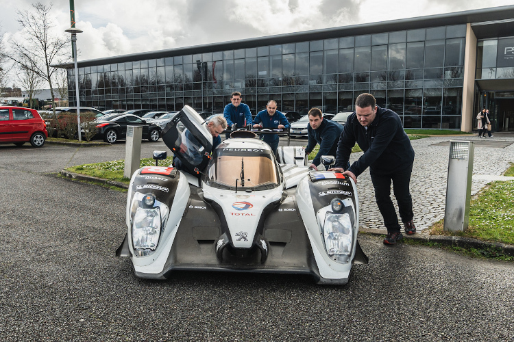 Der Peugeot 908 HYbrid4 wird in Versailles in die Werkstatt gerollt