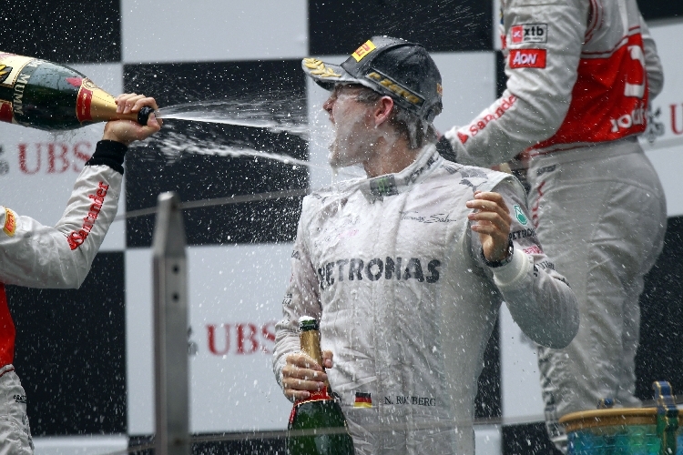 Jenson Button verpasst Nico Rosberg eine Champagner Dusche