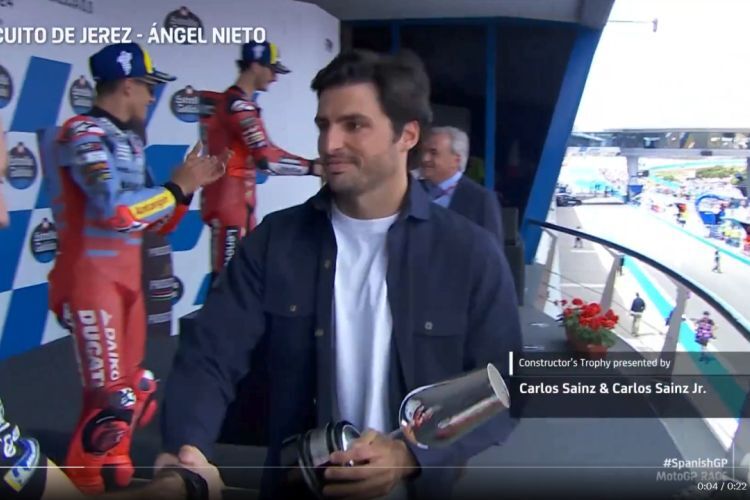 Carlos Sainz jr. vorne und sein Vater Carlos Sainz sr im Hintergrund bei der Pokal-Übergabe der MotoGP in Jerez