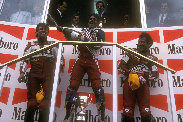 Jarama 1985: Carlos Lavado als Sieger auf dem Podest mit Martin Wimmer (li.) und Toni Mang (re.)