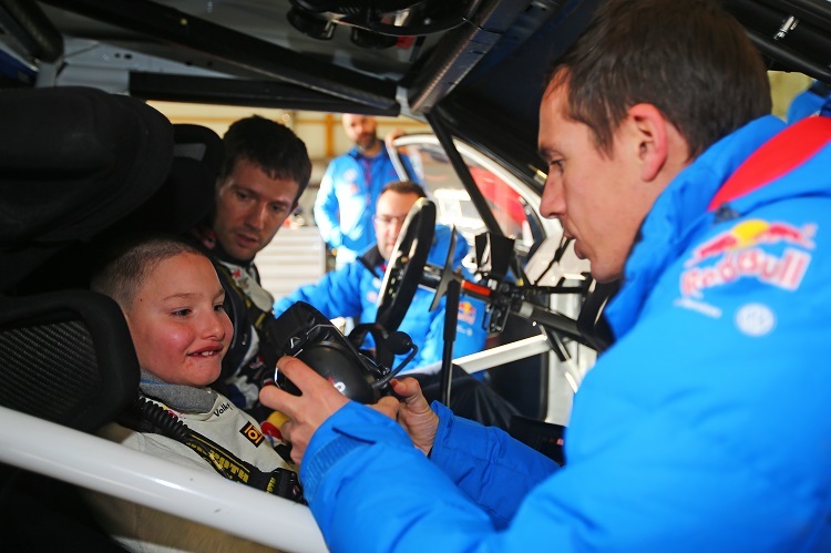 Quentin wird im Weltmeisterauto VW Polo R WRC angeschnallt