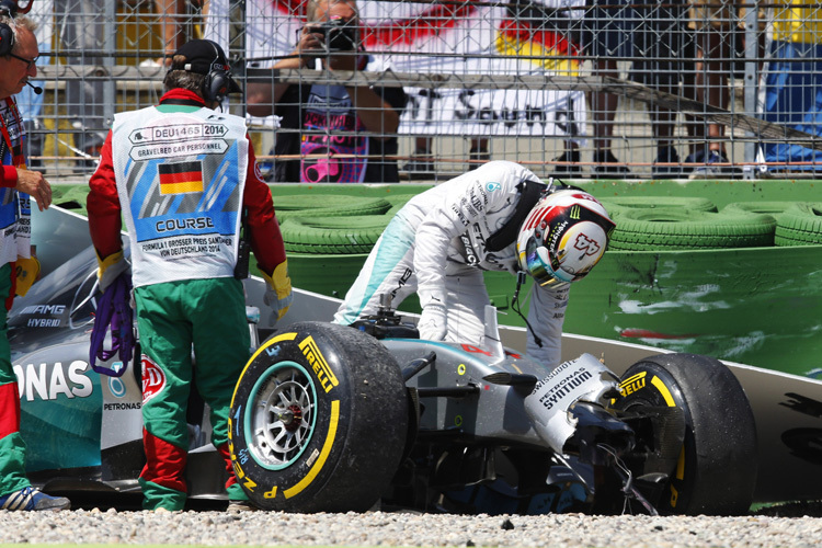 Lewis Hamilton betrachtet den Unfallwagen