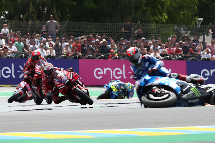 Ein Sinnbild: Links die Ducati-Armada, rechts der stürzende Suzuki-Werksfahrer Alex Rins