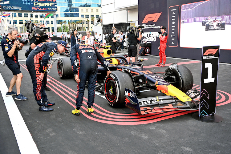 Max Verstappen und Sergio Pérez betrachten nach dem Rennen die Reifen
