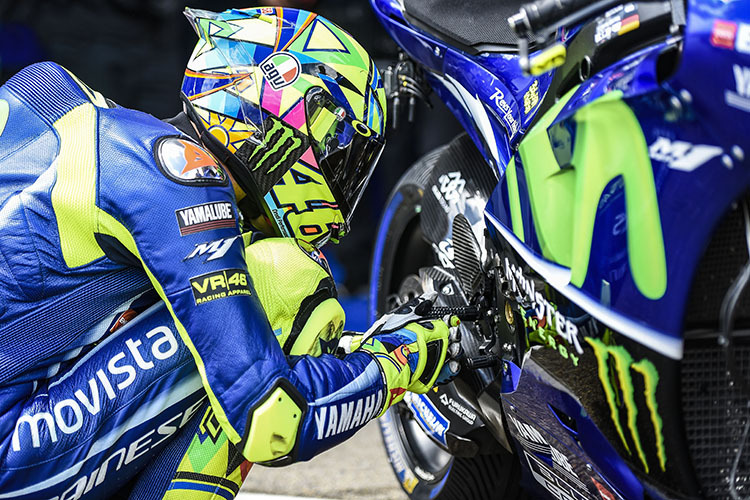 Ritual: Valentino Rossi kniet neben seiner Yamaha