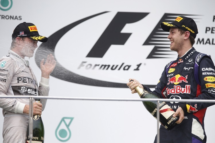 Sebastian Vettel verpasst Nico Rosberg eine Champagner-Dusche