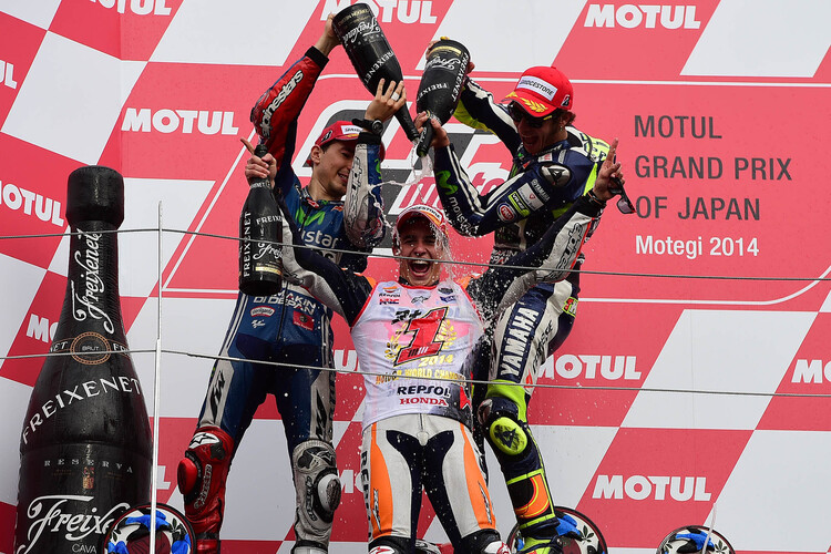 Jorge Lorenzo und Valentino Rossi begiessen Weltmeister Marc Márquez