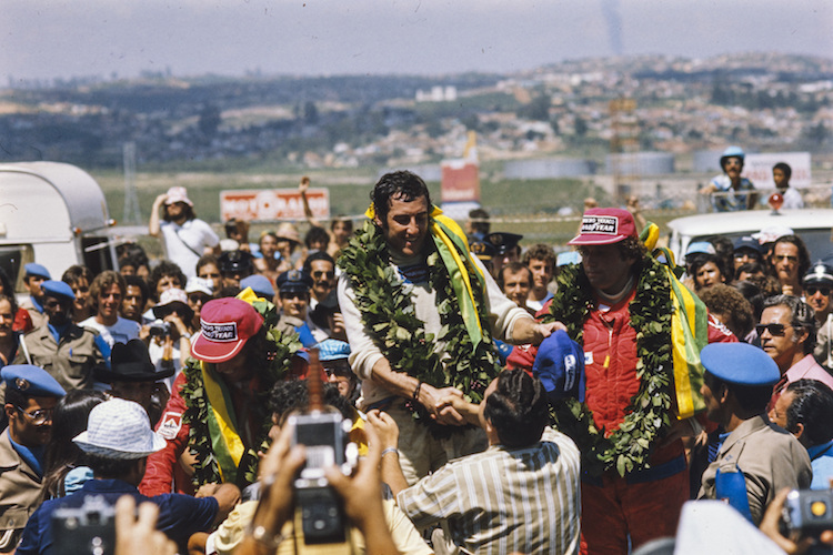 Carlos Pace nach seinem Sieg in Interlagos 1975 (links Emerson Fittipaldi, rechts Jochen Mass)