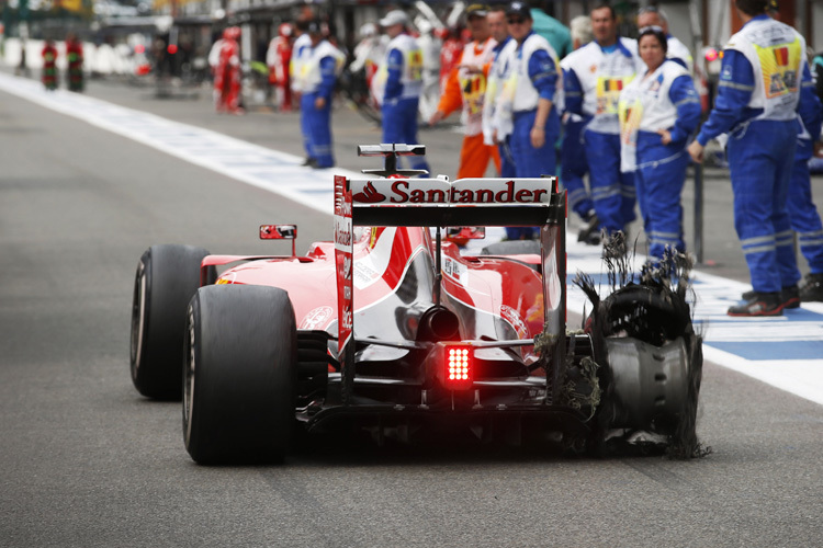 Sebastian Vettel kommt mit in Fetzen liegendem Hinterreifen an die Box