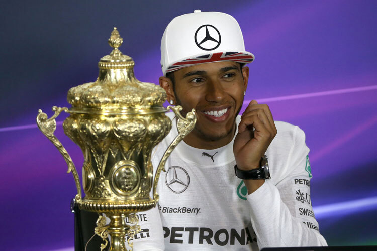 Lewis Hamilton strahlt. Bei der Pressekonferenz gab es endlich den Goldpokal
