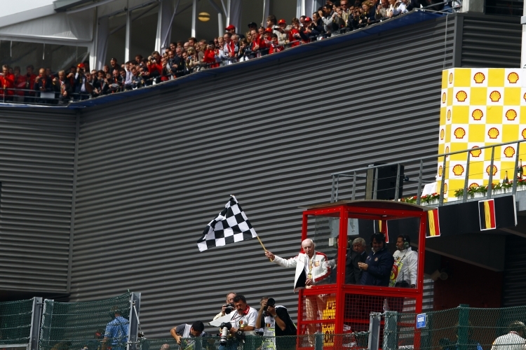 John Surtees schwingt die Zielflagge