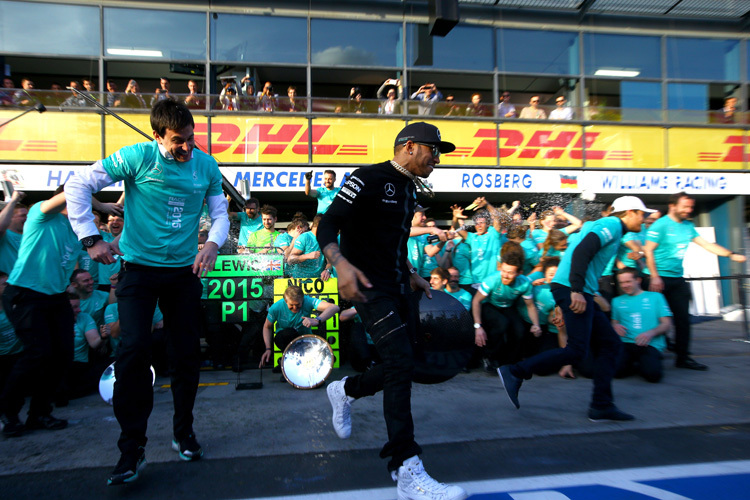 Toto Wolff und Lewis Hamilton fliehen vor einer Champagnerdusche