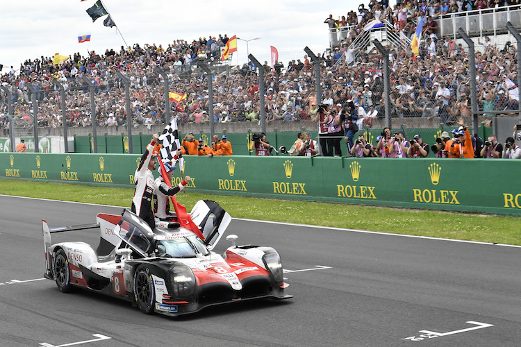 Der Sieger-Toyota von Alonso und Buemi (auf dem Auto) sowie Nakajima (im Wagen)