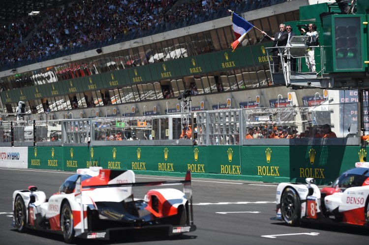 Der Starter der 24h von Le Mans schwenkt traditionsgemäß die französische Nationalflagge