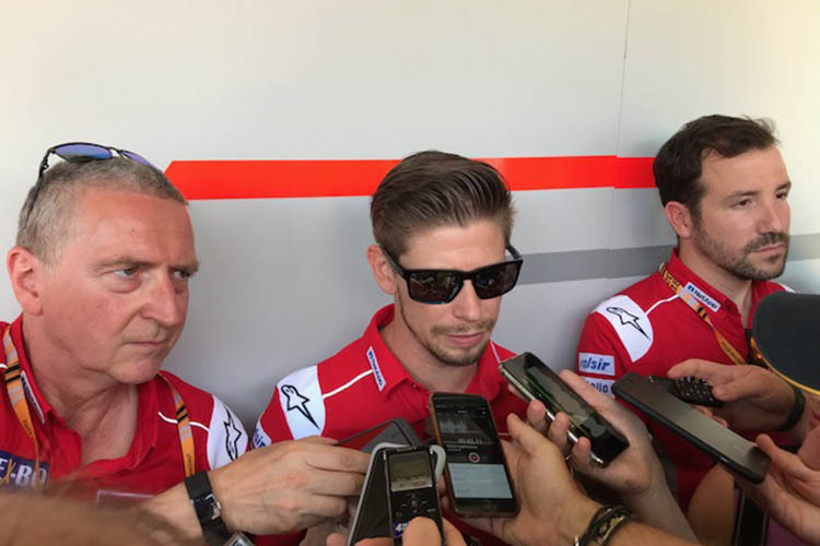 Casey Stoner, umringt von den Ducati-PR-Managern Julian Thomas (li.) und Artur Vilalta