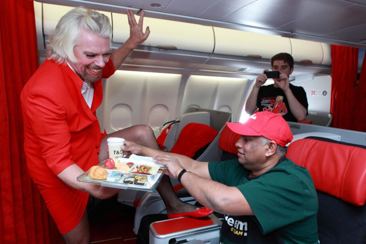Sir Richard Branson ganz in Rot, Tony Fernandes in Grün