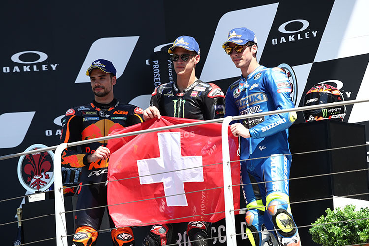 Le top 3 du Mugello: Oliveira, Quartararo et Mir, devant le drapeau suisse pour les morts Jason Duspasquier