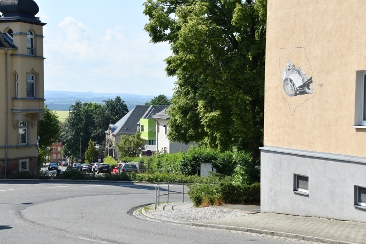 Das Mehrfamilien-Mietshaus in der Badberg-Kurve zeigt den alten 8,618 Kilometer langen Sachsenring und ein Bild der GP-Legende Giacomo Agostini