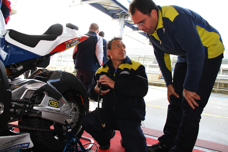 Michelin-Reifentechniker arbeiten am Motorrad von Arie Vos