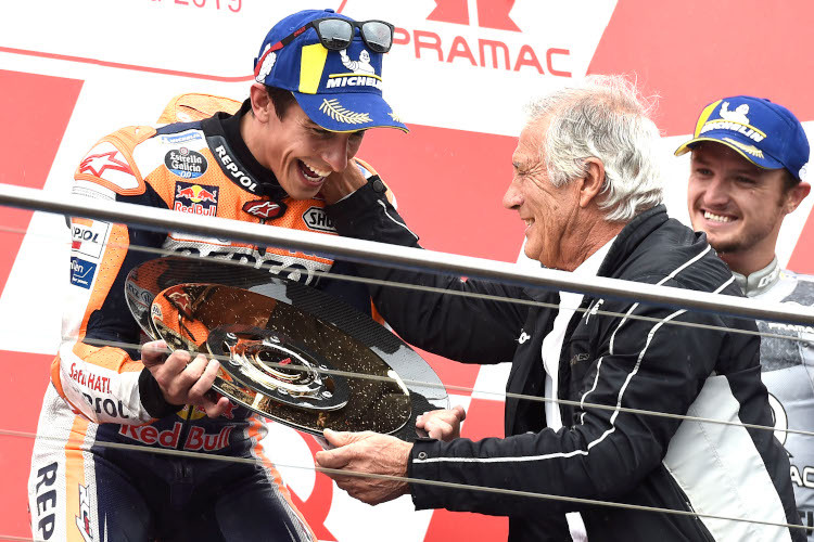 Marc Márquez nimmt die Trophäe aus den Händen von Giacomo Agostini entgegen