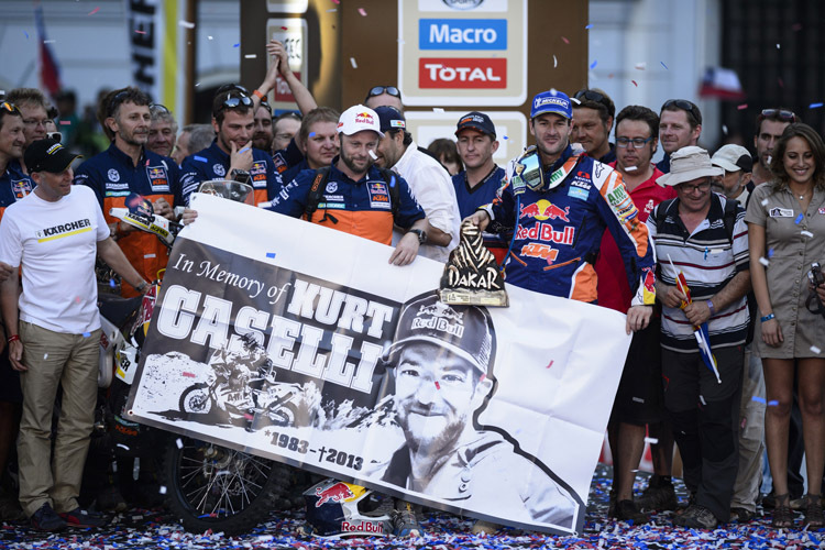 KTM-Teammanager Alex Doringer und Marc Coma mit dem Kurt-Caselli-Banner auf dem Dakar-Podest