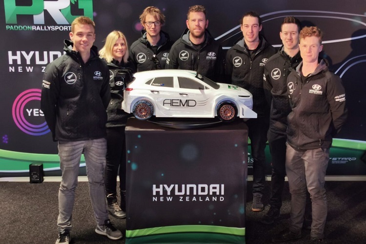 Hayden Paddon (vorne) mit seinem Team und dem E-Auto