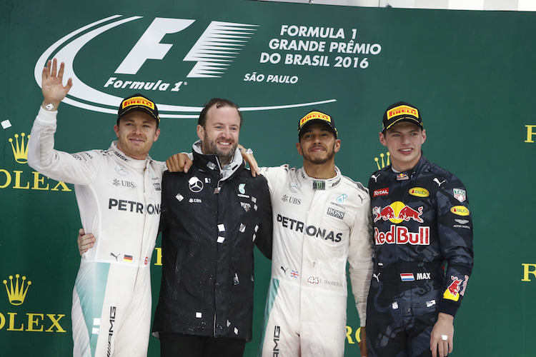 Nico Rosberg (links) und Max Verstappen (rechts) mit Lewis Hamilton auf dem Siegerpodest von Brasilien 2016. Dazwischen der Mercedes-Mediendelegierte Bradley Lord