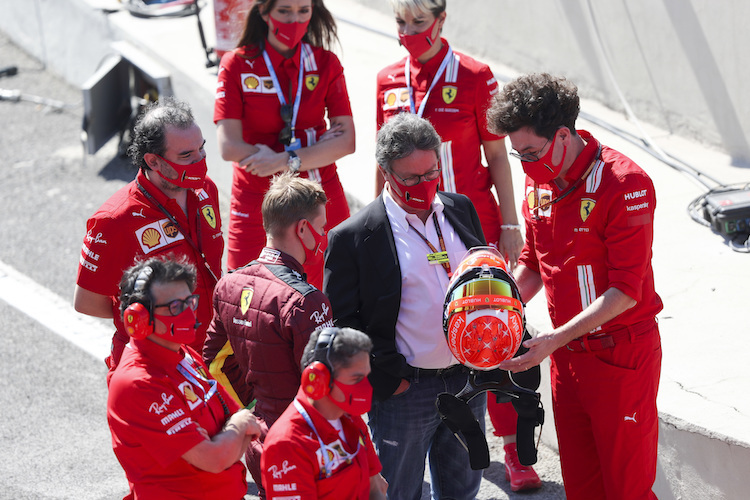 Ferrari-Teamchef Mattia Binotto (rechts) zeigt CEO Louis Camilleri den Helm von Mick Schumacher