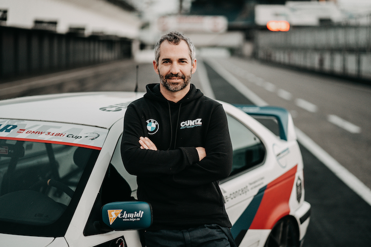 Timo Glock vor dem Markenpokalfahrzeug des DMV BMW 318ti Cup