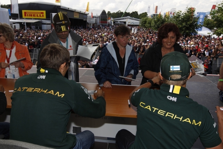 Heikki Kovalainen und Vitaly Petrov geben Autogramme
