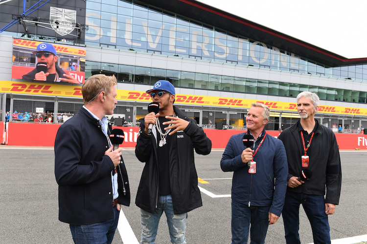 Lewis Hamilton mit Damon Hill (ganz rechts) und Johnny Herbert (Zweiter von rechts), links Craig Slater von Sky